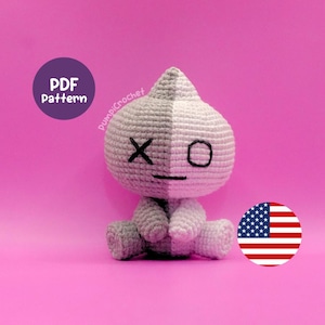 May include: A two-toned gray and white crocheted plush toy with a pointed top, featuring a black embroidered X for one eye, a black circle for the other eye, and a straight black line for a mouth. The image includes a purple circle with PDF Pattern text.