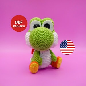 Può includere: Bambola Yoshi all'uncinetto fatta a mano, verde, bianca, arancione e gialla. La bambola ha grandi occhi neri ed è seduta. L'immagine include un cerchio rosso con il testo "PDF Pattern" e una bandiera americana.