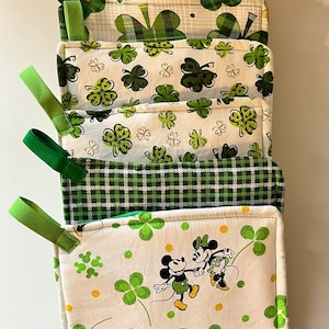 May include: Set of six green and white pot holders with a variety of patterns, including shamrocks, plaid, and Mickey Mouse.