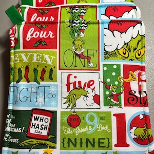 May include: Set of four red, green, and white pot holders featuring a Grinch theme. The pot holders have different numbers and phrases, including "Who Hash", "The Grinch is Back", and "Nine".