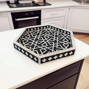 May include: A hexagonal tray with a black and white geometric pattern. The tray is made of bone inlay and has a white border with black accents.