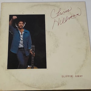 May include: Album cover featuring a man in a denim jacket and jeans, holding a guitar. The cover has the text "Chris Hillman" in red script and the title "Slippin' Away" at the bottom.
