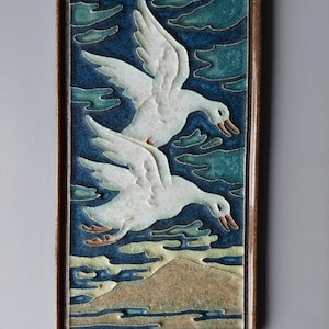 A cloisonne tile from the Porceleyne Fles of 2 geese flying to the right.