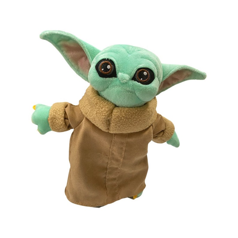 May include: A plush toy of a character with large brown eyes, green skin, and large ears. The character is wearing a tan coat with a brown collar. The toy's arms are outstretched, and it has yellow accents on its fingers.