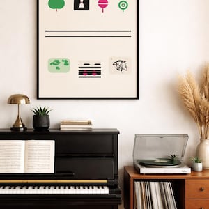 May include: A framed art print with abstract geometric shapes in green, black, and pink. The artwork hangs above a black piano with sheet music, a gold lamp, and a record player on a wooden cabinet.