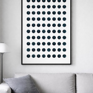 Puede incluir: Impresión artística abstracta con una cuadrícula de círculos azul oscuro, cada uno con detalles turquesa. La obra de arte está enmarcada en negro y cuelga de una pared blanca sobre un sofá gris.