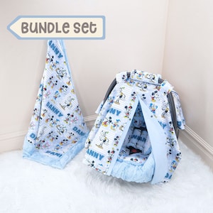 May include: A blue and white baby car seat cover with a Mickey Mouse print and the name "Danny" on it. The cover is part of a bundle set that also includes a matching blanket.