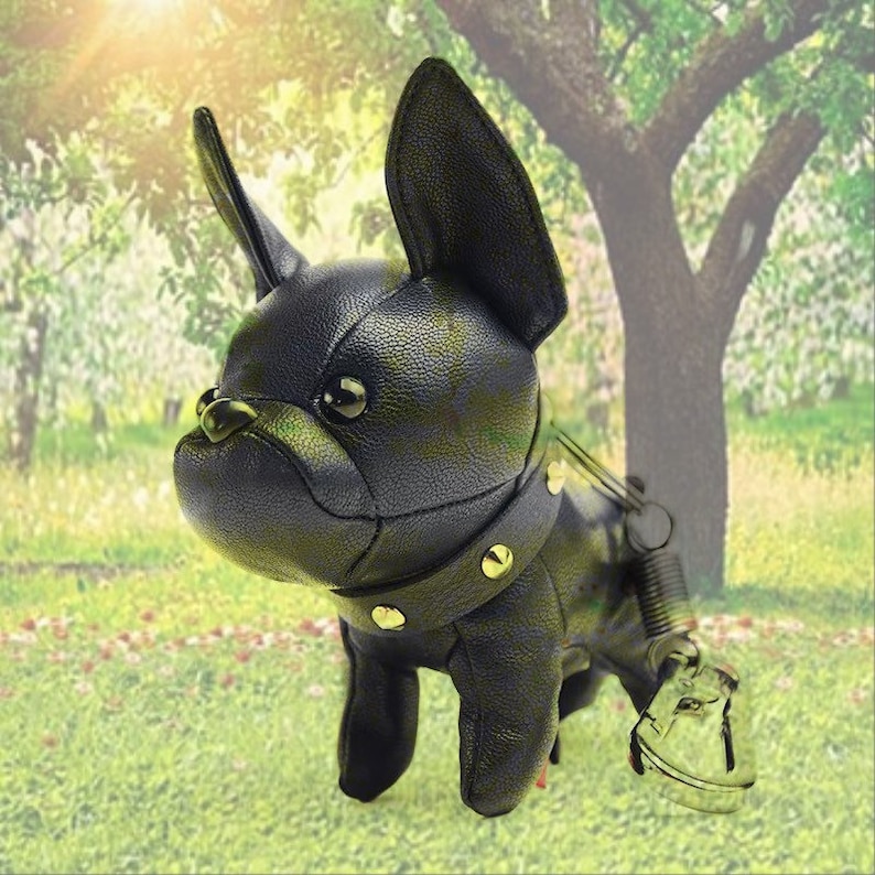 May include: Black leather French bulldog keychain with gold accents and a spring clip.