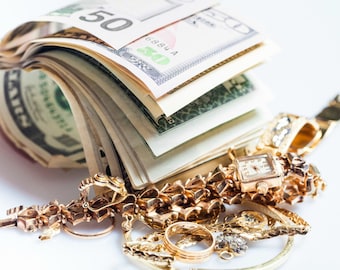 Könnte beinhalten: Ein Stapel US-Dollar-Scheine mit einem 50-Dollar-Schein obenauf und ein Haufen Goldschmuck, darunter eine Uhr, Armbänder und Ringe.