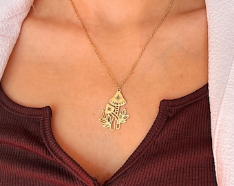 May include: A gold necklace with a mushroom pendant. The mushroom has a star and crescent moon design.