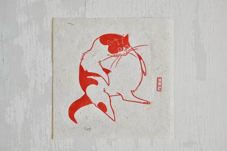 May include: Red and white illustration of a cat printed on a cream-colored paper. The cat is sitting with its back to the viewer and its head turned to the side. The cat's tail is curled around its body. The image is signed "Bing" in the bottom left corner.