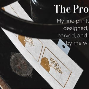 May include: A close-up of a printing press with two lino prints of a floral design. The text "The Process" is above the prints and reads "My lino prints are all designed, drawn, carved, and printed by me with love."