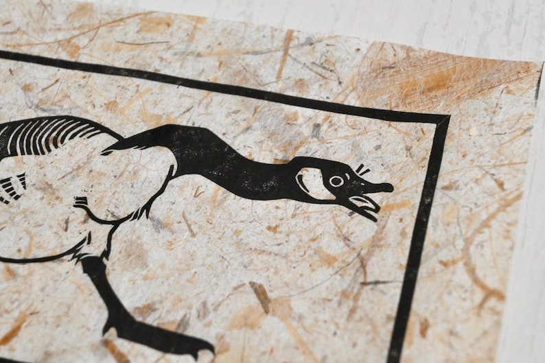 May include: Black and white illustration of a goose with its head turned to the side, printed on a textured paper background.