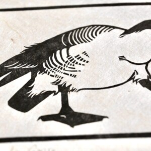 May include: Black and white illustration of a goose with its head turned back, looking at its tail feathers. The goose is depicted in a simple, stylized manner, with its body outlined in black and its feathers represented by a series of lines.