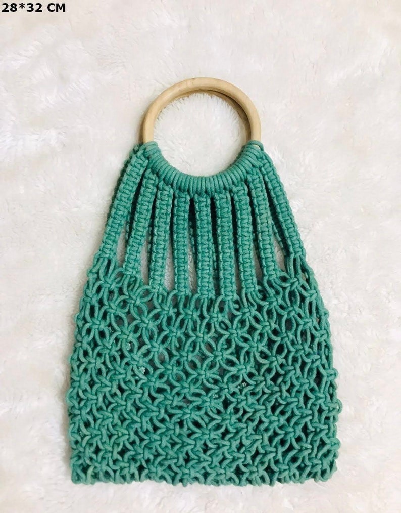 May include: A teal blue crocheted tote bag with a wooden ring handle. The bag is 28 by 32 centimeters.