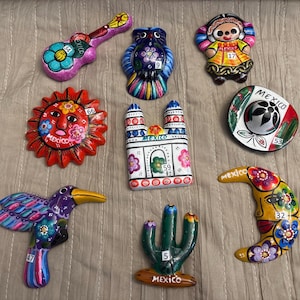Mexican Ceramic II. Mexican ceramic magnets, charro hats, and metal figures. All with traditional designs.