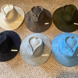 K&ouml;nnte beinhalten: Sechs Filzh&uuml;te in verschiedenen Farben, jeder mit einer herzf&ouml;rmigen Krone. Die H&uuml;te sind mit den Farben beschriftet: "Lt. Light Gray", "Lt. Gray", "Olive Green", "Lt. Blue Navy", "Lt. Blue Jeans" und "Lt. Turquoise".