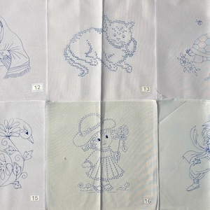 May include: A set of six white fabric squares featuring blue ink embroidery transfer patterns. The designs include a person with tulips, a cat, a turtle, a swan with flowers, a child with a hat and rose, and a spiky-haired character, numbered 12 to 17.