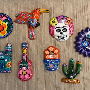 Mexican Ceramic III. Mexican ceramic magnets, charro hats, and metal figures. All with traditional designs.