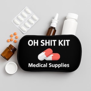May include: Black rectangular "OH SHIT KIT" medical supplies bag with two red and white capsules. The bag is surrounded by pills, a nasal spray bottle, and a white medicine bottle. The text "Medical Supplies" is below the capsules.