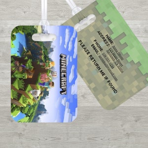 May include: Two Minecraft-themed luggage tags. One tag features a landscape scene with the game's logo. The other tag has a pixelated green and tan design with contact information: name, address, phone, and email. Both tags have clear plastic loops.