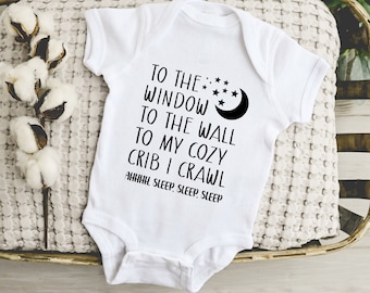 May include: White baby onesie with black text that reads "To the window to the wall to my cozy crib I crawl AHHH, sleep, sleep, sleep". The onesie has a black crescent moon and stars graphic.