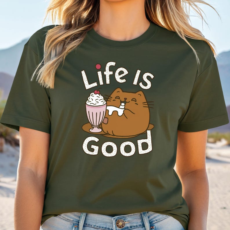 May include: A green t-shirt with a cartoon cat enjoying a milkshake. The text "Life is Good" is printed on the shirt.