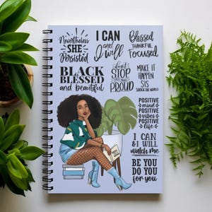 May include: A blue spiral bound journal with an illustration of a Black woman with an afro, wearing a green sweater, blue denim shorts, and fishnet stockings. The journal has inspirational quotes and affirmations, including "Black Blessed and Beautiful", "I Can and I Will", "Don't Stop Until You're Proud", "Make It Happen Sis", "Positive Mind, Positive Vibes, Positive Life", and "Be You Do You For You".