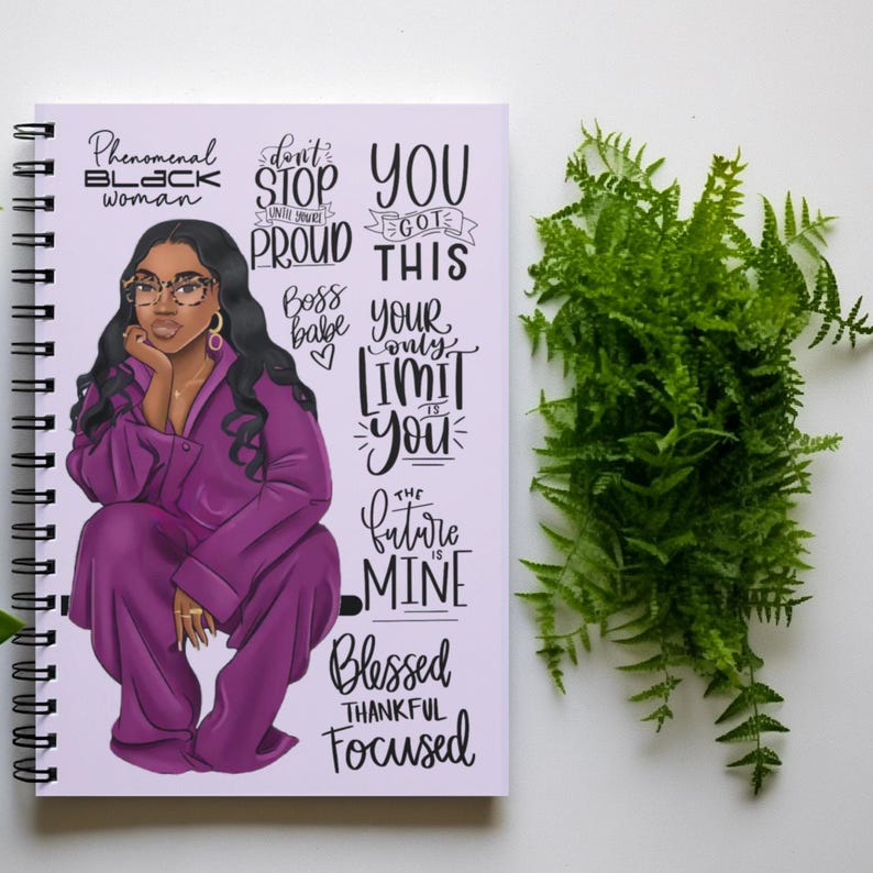 May include: A purple spiral bound notebook with an illustration of a Black woman wearing a purple outfit and glasses. The notebook has inspirational text including "Phenomenal Black Woman", "Don't Stop Until You're Proud", "You Got This", "Boss Babe", "Your Only Limit Is You", "The Future Is Mine", "Blessed Thankful Focused".