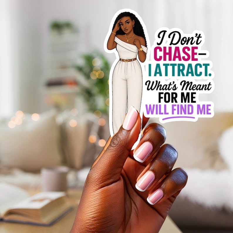 May include: A sticker featuring a stylish woman in a white jumpsuit with a gold belt and jewelry. The sticker has the text "I Don't Chase - I Attract. What's Meant For Me Will Find Me" in black, teal, and purple.