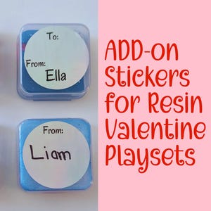 May include: Four small, square containers with blue contents and clear lids. Each has a white circle label with "To:" and "From:" written on it. One label says "From: Ella" and another says "From: Liam". Text on the right reads "ADD-ON Stickers for Resin Valentine Playsets."