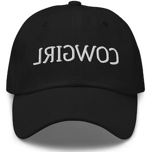 May include: Black baseball cap with white embroidered text that reads "COWGIRL" backwards.