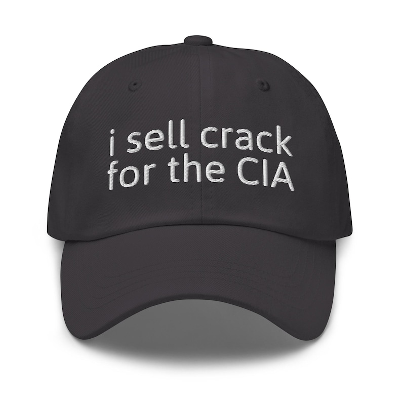May include: A black baseball cap with white embroidered text that reads "i sell crack for the CIA".
