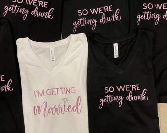 May include: Five white and black t-shirts with pink glitter text. The shirts say "So we're getting drunk" and "I'm getting married".