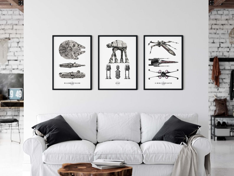 May include: Three black framed prints of Star Wars vehicles. The left print shows the Millennium Falcon, the middle print shows an AT-AT, and the right print shows an X-Wing Starfighter.
