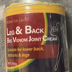 Puede incluir: Un frasco de crema para articulaciones Leg & Back Bee Venom. La etiqueta es roja y presenta el texto "Leg & Back" en letras blancas grandes. El frasco es amarillo y tiene una tapa plateada. La etiqueta tambi&eacute;n indica que la crema es adecuada para la parte baja de la espalda, las nalgas y las piernas. Peso neto: 100g.
