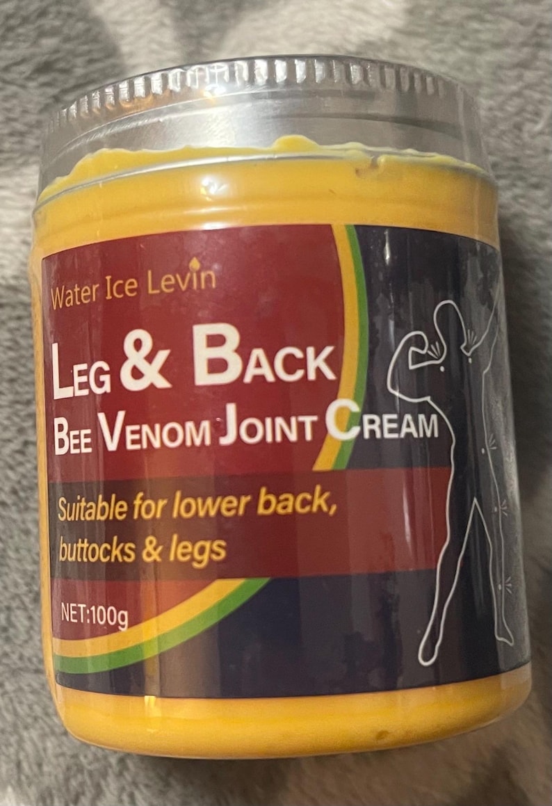 Puede incluir: Un frasco de crema para articulaciones Leg & Back Bee Venom. La etiqueta es roja y presenta el texto "Leg & Back" en letras blancas grandes. El frasco es amarillo y tiene una tapa plateada. La etiqueta tambi&eacute;n indica que la crema es adecuada para la parte baja de la espalda, las nalgas y las piernas. Peso neto: 100g.