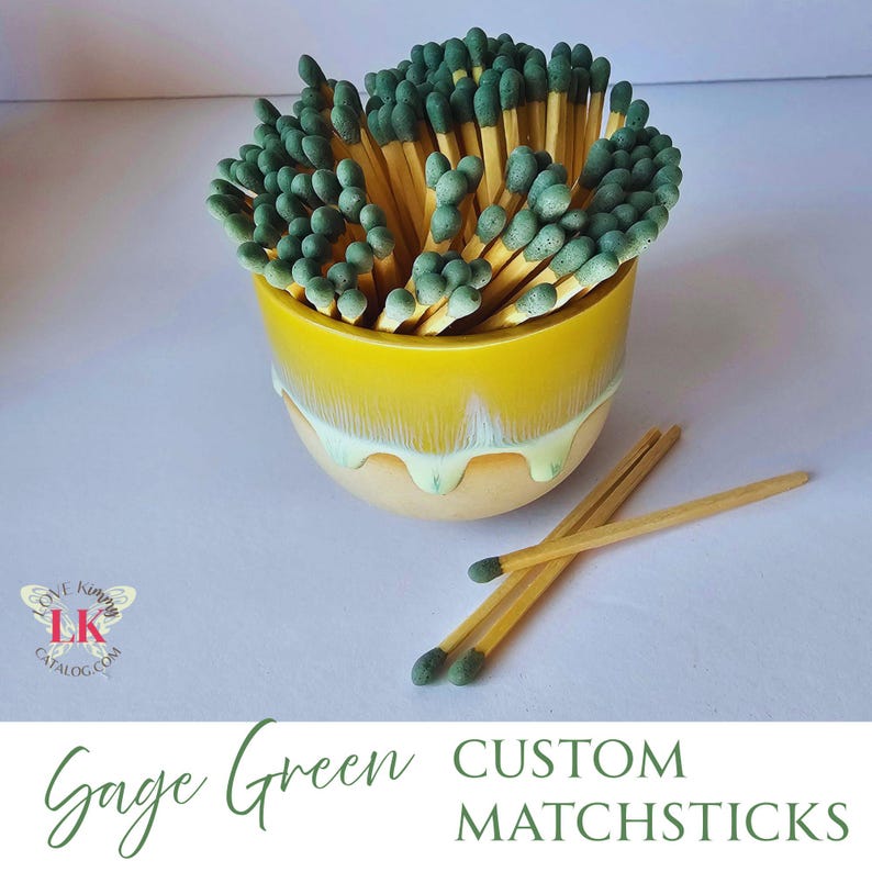 May include: A yellow ceramic bowl filled with green and yellow matchsticks. The bowl has a white glaze that drips down the sides.  There are three green and yellow matchsticks on a white surface next to the bowl.