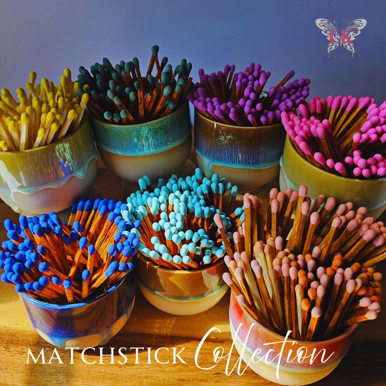 May include: A collection of colorful matchsticks in ceramic containers. The matchsticks are arranged in different colors, including yellow, blue, purple, pink, and green. The containers are decorated with a variety of patterns and designs.