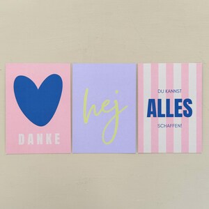 May include: Three square cards with text and designs. The first card is pink with a blue heart and the word "DANKE". The second card is lavender with the word "hej" in yellow. The third card is striped pink and white with German text.