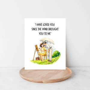 Może przedstawiać: Kartka okolicznościowa z ilustracją pary pod parasolem. Kobieta maluje na sztaludze. Na kartce widnieje napis: "I HAVE LOVED YOU SINCE THE WIND BROUGHT YOU TO ME."