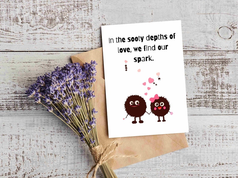 May include: A greeting card with the text "In the sooty depths of love, we find our spark." features two cartoon characters holding hands. A bundle of lavender and a brown envelope are also in the image.