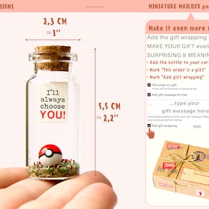 May include: A small glass bottle with a cork stopper, containing a red and white Pokeball and green and brown dried herbs. The bottle is 2.3 cm in diameter and 5.5 cm tall. The bottle has a label that reads "I'll always choose YOU!"
