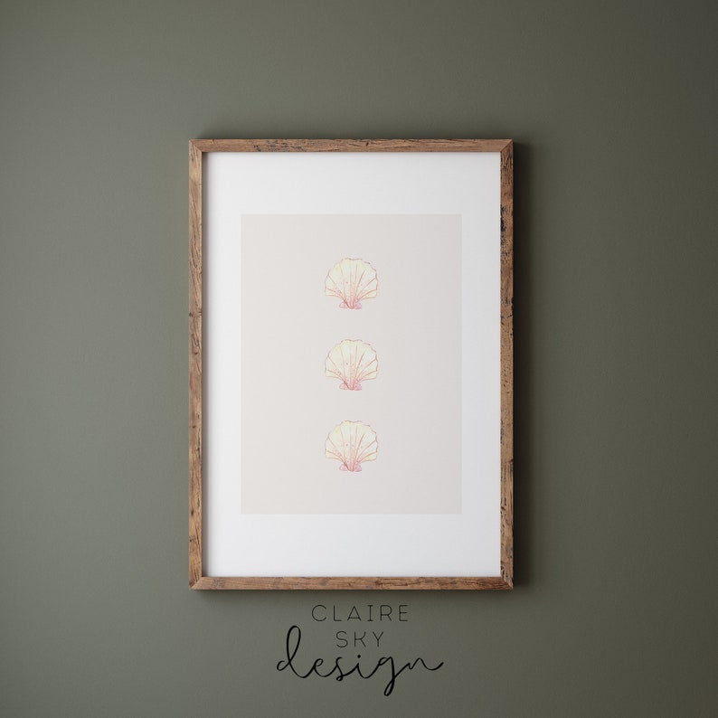 May include: A framed print with three stylized pink and yellow seashells in a vertical line. The print is on a light beige background. The frame is brown wood. The text below the print reads 'CLAIRE SKY design'.