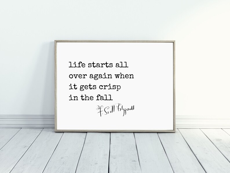 May include: A black and white typography print with the quote "Life starts all over again when it gets crisp in the fall" by F. Scott Fitzgerald.