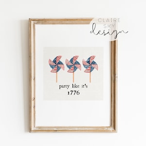 Op de afbeelding: Een ingelijst afdruk met drie rood, wit en blauwe windmolens met de tekst "party like it's 1776".