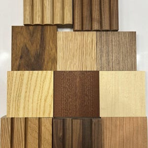 May include: A collection of wooden samples showcasing various grains and colors. The samples include rectangular blocks and cylindrical pieces, ranging from light beige to dark brown. The image highlights the natural textures and tones of different wood types.