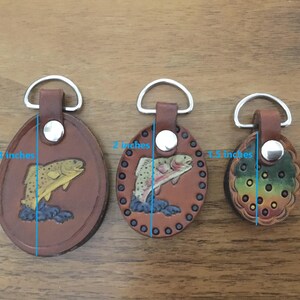 Puede incluir: Tres llaveros de cuero con diferentes dise&ntilde;os. El llavero m&aacute;s grande mide 2,5 pulgadas de alto y presenta una trucha marr&oacute;n. El llavero del medio mide 2 pulgadas de alto y presenta una trucha marr&oacute;n. El llavero m&aacute;s peque&ntilde;o mide 1,5 pulgadas de alto y presenta un dise&ntilde;o multicolor.