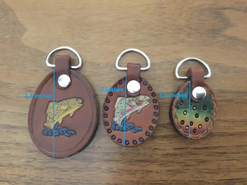 Puede incluir: Tres llaveros de cuero con diferentes dise&ntilde;os. El llavero m&aacute;s grande mide 2,5 pulgadas de alto y presenta una trucha marr&oacute;n. El llavero del medio mide 2 pulgadas de alto y presenta una trucha marr&oacute;n. El llavero m&aacute;s peque&ntilde;o mide 1,5 pulgadas de alto y presenta un dise&ntilde;o multicolor.