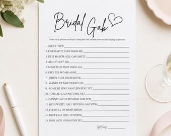 May include: A white rectangular game card titled Bridal Gab with a black heart icon. The card features fifteen numbered lines for a word puzzle game, with instructions to decipher love-related phrases. The text is printed in black ink.
